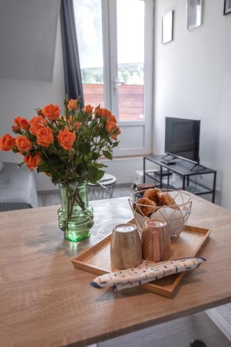 un vase de fleurs orange assis sur une table dans l'établissement Le Nid vue et détente à Etienne, à Saint-Étienne