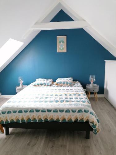 a bedroom with a blue wall and a bed at Gite 12 personnes avec piscine in Malguénac