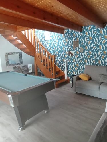 a pool table in a living room with a couch at Gite 12 personnes avec piscine in Malguénac