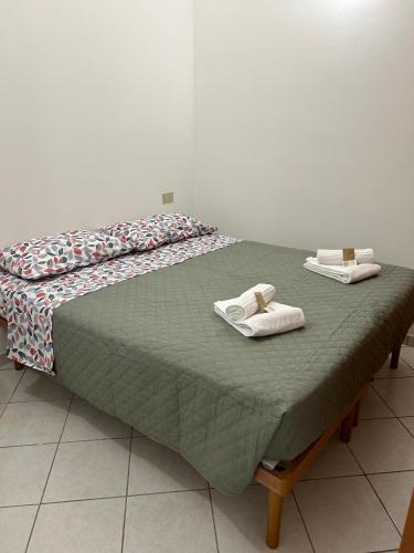 a bed with two towels on top of it at Sweet Room MARY in Santa Maria Maddalena