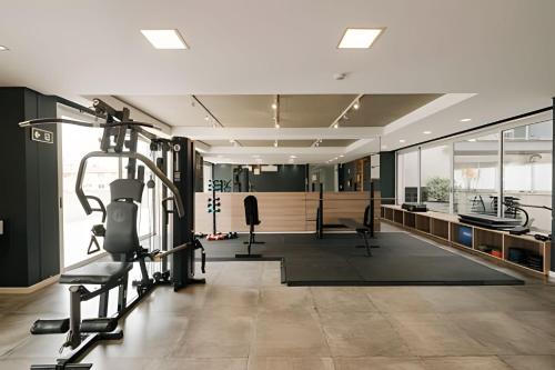 a gym with treadmills and machines in a room at Novinho, Central e c/ Garagem! in Pelotas