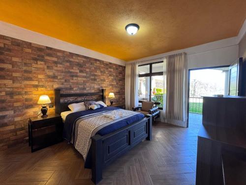 a bedroom with a bed and a brick wall at Hotel Mercy in San Juan La Laguna