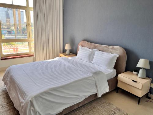 a bedroom with a large bed with white sheets and pillows at ليالينا فيو Layali View Family and Business 3 bed rooms 13 in King Abdullah Economic City