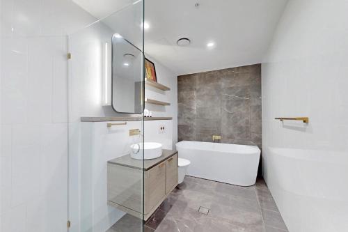 a bathroom with a tub and a toilet and a sink at Beach Front 2BR Meriton Sunrise & Ocean Views in Gold Coast