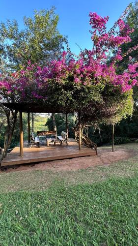 a pavilion with picnic tables and purple flowers at SR Farm Hotel in Brotas