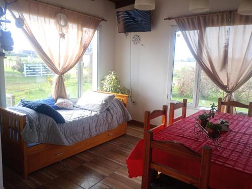 a bedroom with two beds in a room with windows at Rincón del Sol in Tandil