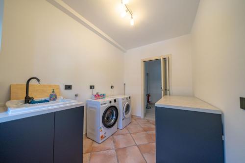 a laundry room with a washing machine and a sink at Spinedi Royale in Postalesio