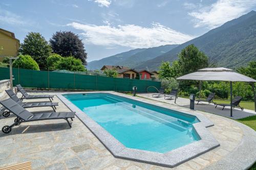 a swimming pool with two chairs and an umbrella at Spinedi Royale in Postalesio