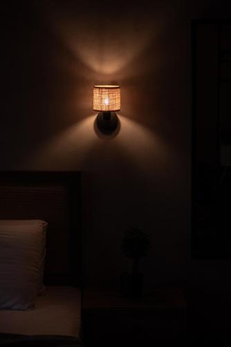 a lamp on the corner of a room with a bed at AURA sophisticated living in Nea Kalikratia