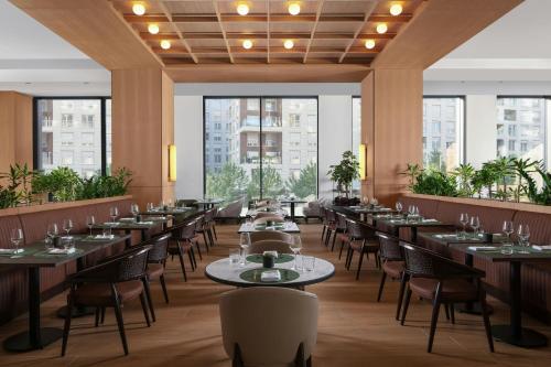 a restaurant with tables and chairs and large windows at Courtyard by Marriott Prishtina in Pristina