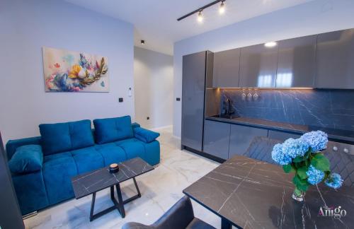 Una sala de estar con un sofá azul y una mesa. en Prestige, en Mostar