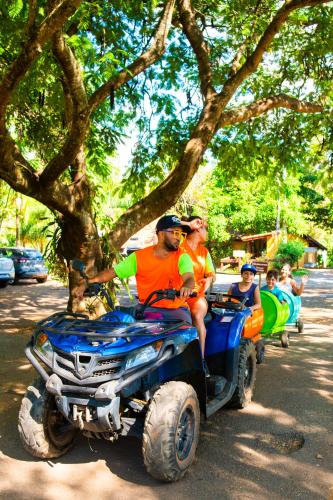 a group of people riding on an atv under a tree at SR Farm Hotel in Brotas