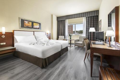 a hotel room with a large bed and a desk at Elba Almeria Business & Convention Hotel in Almería