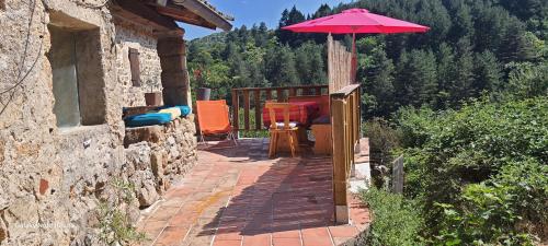 a patio with a table and an umbrella at Gîte du Barbier07 in Rocles