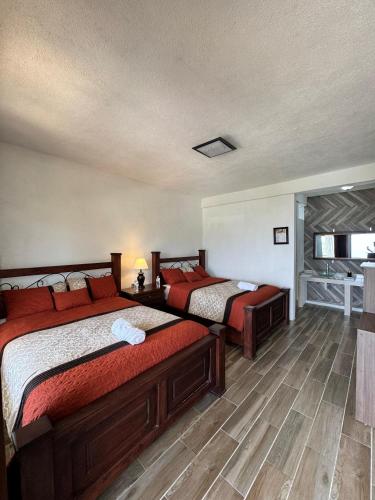 a bedroom with two beds with red pillows at Hotel Mercy in San Juan La Laguna
