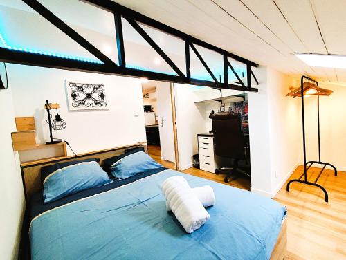 - une chambre avec un lit doté de draps bleus et d'oreillers bleus dans l'établissement T2 neuf tout confort style industriel -centre Agen, à Agen