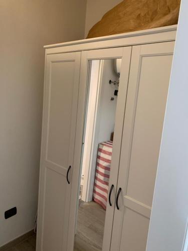 a white cabinet with a mirror in a room at La casetta di Sonia in Sarnico
