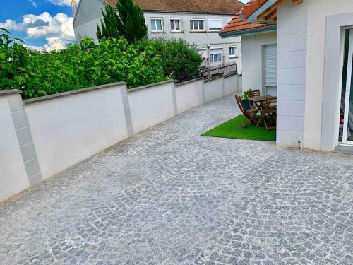 a patio of a house with a table and chairs at Studio proximité Paris Le Bourget in Arnouville-lès-Gonesse