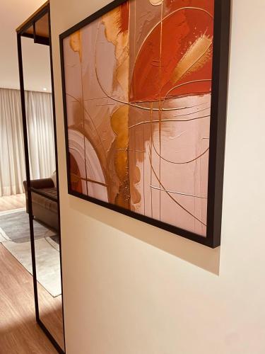 a painting hanging on a wall next to a mirror at Pousada Cantinho da Serra in Campos do Jordão