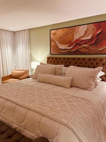 a bedroom with a large bed and a large painting at Pousada Cantinho da Serra in Campos do Jordão