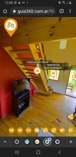 a view of a living room with a tv and a staircase at Cabañas Wairoa Haus in Villa General Belgrano
