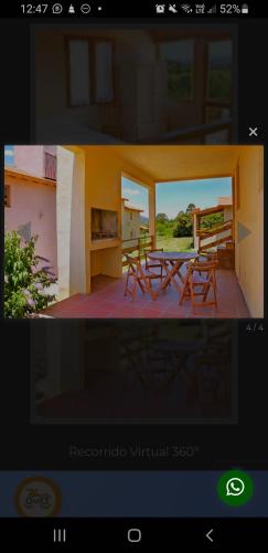 a picture of a porch with a table and chairs at Cabañas Wairoa Haus in Villa General Belgrano