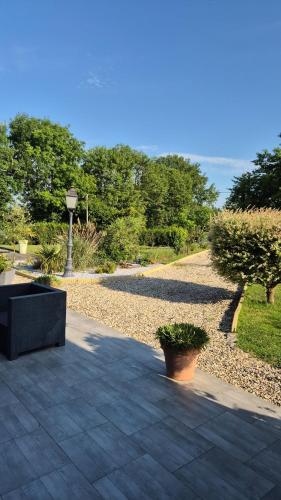 a patio with a bench and a street light at La petite normande in Appeville-Annebault