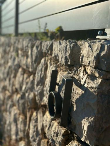 a stone wall with a black object on it at Villa Poljana in Mali Lošinj