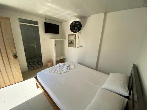 a small bedroom with a bed and a clock on the wall at Hotel Lina Maria in Tuluá