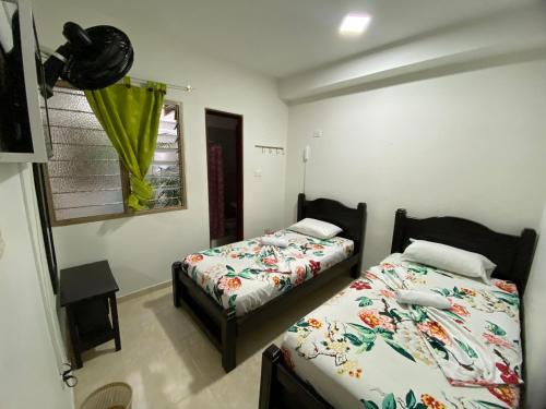 a bedroom with two beds and a window at Hotel Lina Maria in Tuluá