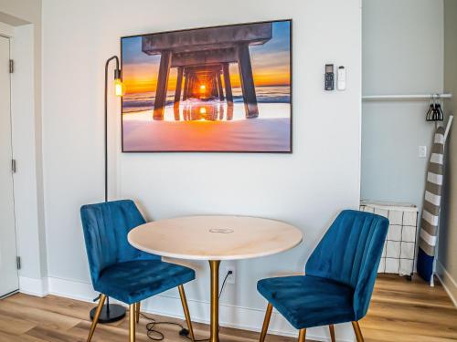 a table and chairs in a room with a picture on the wall at The Bosun Locker at Seahorse Rentals in Jacksonville Beach