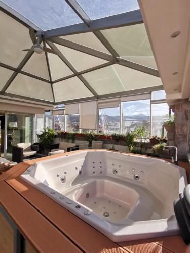 a large white tub in a room with windows at Suites Cusco in Cusco