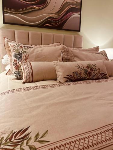 a bed with several pillows on top of it at Pousada Cantinho da Serra in Campos do Jordão
