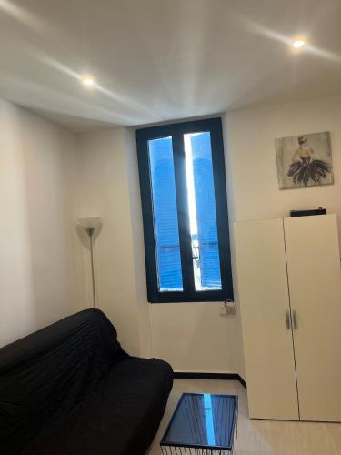 Cette chambre comprend un lit, une fenêtre et une table en verre. dans l'établissement Spacieux studio avec coin nuit, à Vallauris