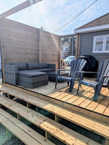 un patio con 2 sillas y un sofá en una terraza en Hatchet Harbour Cottage, en Herring Neck