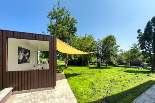 a small house with a yellow tent in a field at Apartmány Stříbřec 146 in Jindrichuv Hradec
