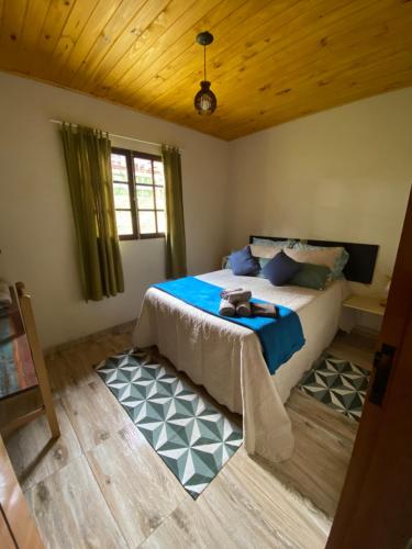 a bedroom with a bed with blue sheets and a window at Sitio Pera da agua in Santa Luísa de Baixo