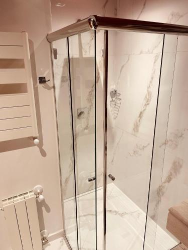 a shower with a glass door in a bathroom at Pousada Cantinho da Serra in Campos do Jordão