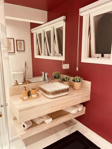 a bathroom with a sink and a red wall at Pousada Cantinho da Serra in Campos do Jordão