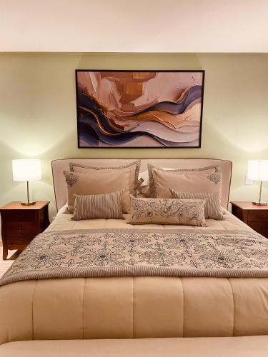 a bedroom with a large bed with two lamps at Pousada Cantinho da Serra in Campos do Jordão
