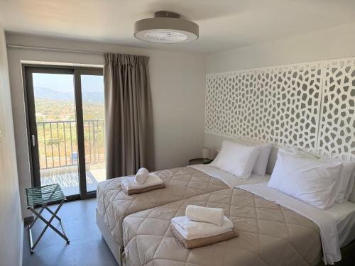 a bedroom with a large bed with two towels on it at Sunrise Village Aptera Private Pool Villa in Beritianá