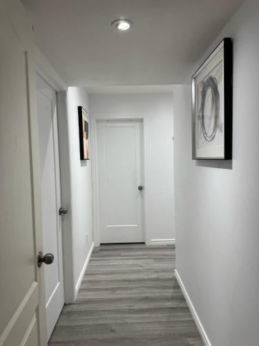 a hallway with white walls and a white door at Heavenly Cozy Place Inc in Airdrie