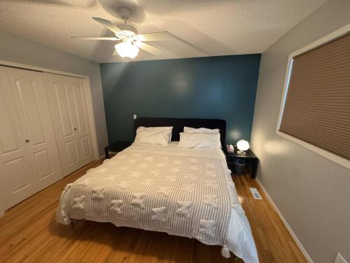 a bedroom with a bed and a ceiling fan at Heavenly Cozy Place Inc in Airdrie