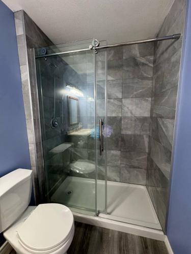 a bathroom with a shower and a toilet at Heavenly Cozy Place Inc in Airdrie