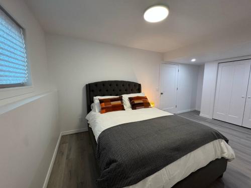 a bedroom with a large bed with orange pillows at Heavenly Cozy Place Inc in Airdrie
