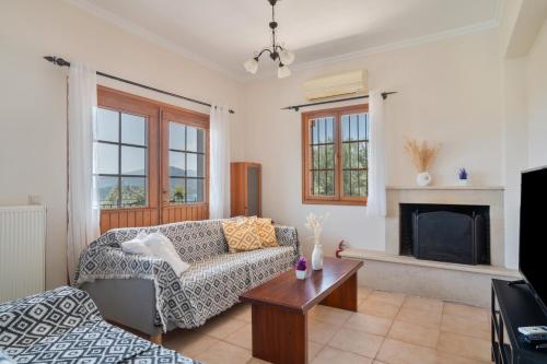 un salon avec un canapé et une cheminée dans l'établissement Villa Melikokia, à Lygia