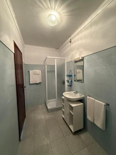 a bathroom with a sink and a shower at Alojamento Dona Inês de Castro in Atouguia da Baleia