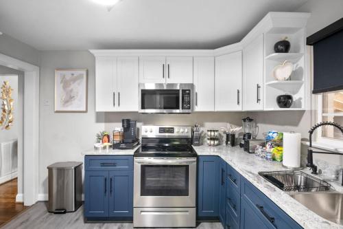 una cucina con mobili blu e un forno a piano cottura di Family Fun! 2 Story Oasis and Pup Retreat Near RVA! a Richmond