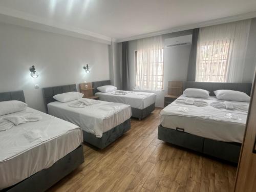 a room with three beds and two windows at Avka Palace in Edirne