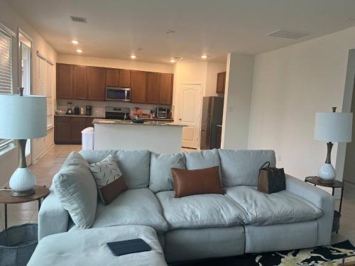 a living room with a couch and a kitchen at Summerhouse Villa 4br 2 and half ba Home in Rosharon